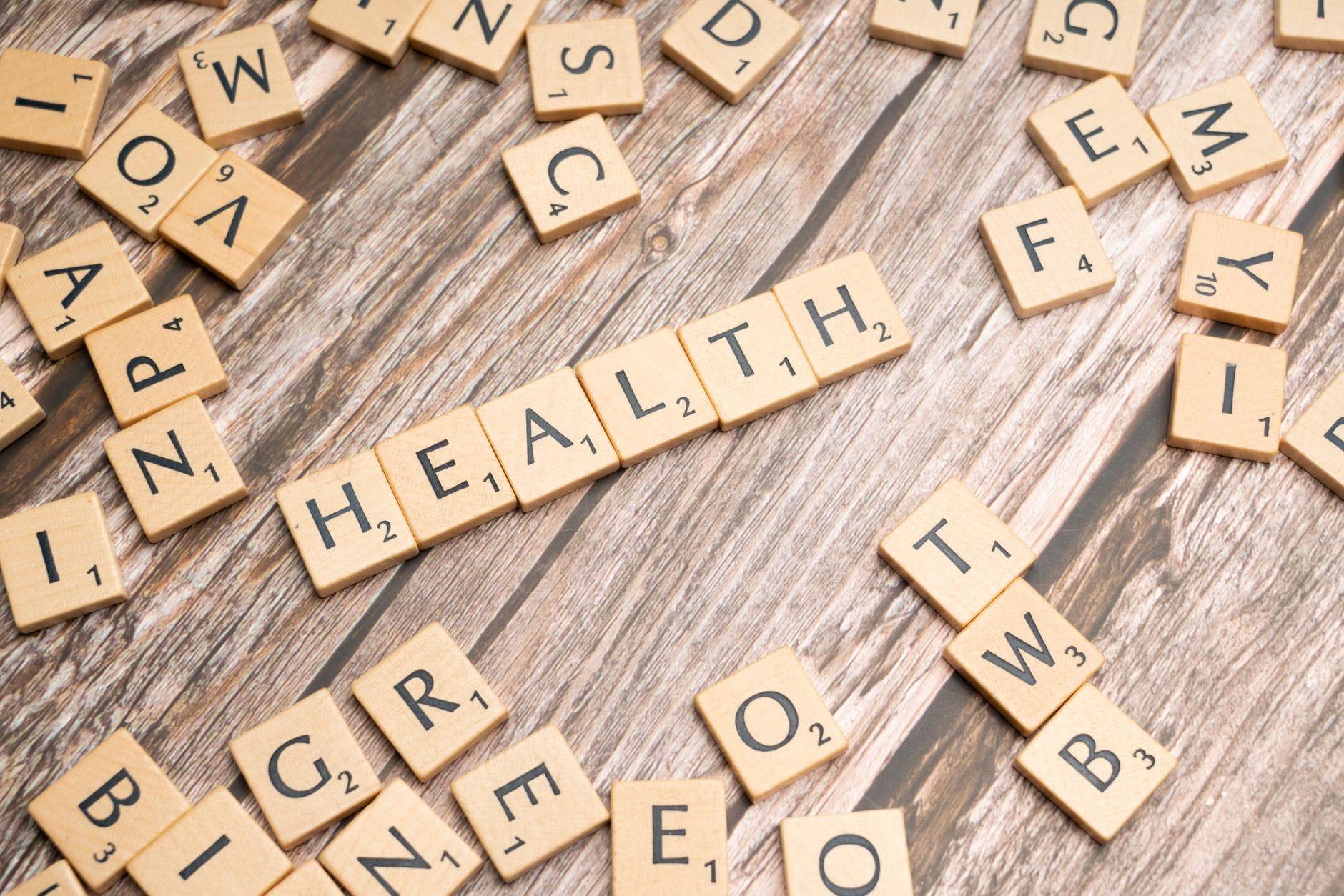 Kafelki Scrabble układające słowo HEALTH na drewnianej powierzchni